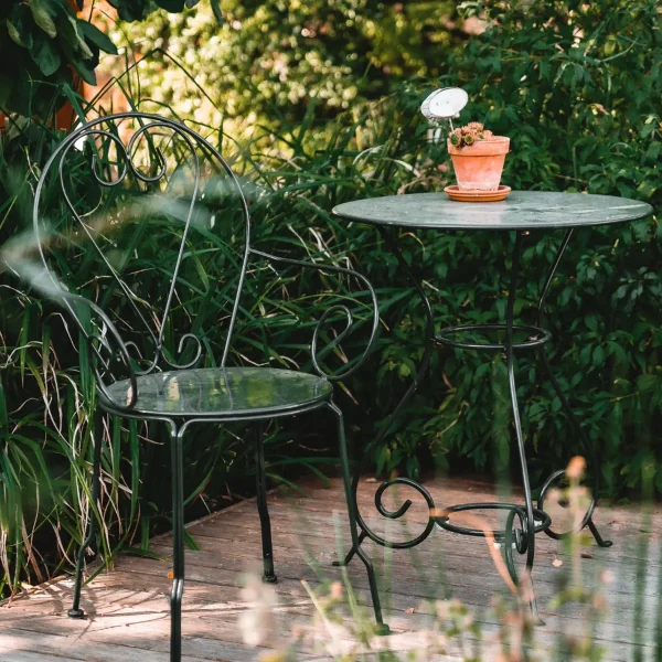 Metallsessel und Tisch auf der Teichterrasse im Gästehaus Luger